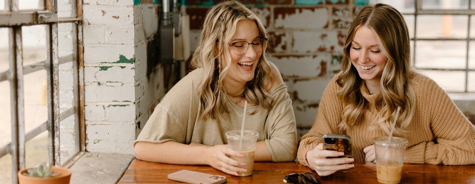 a couple of women sitting at a table with drinks