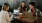 a group of people sitting at a table with laptops